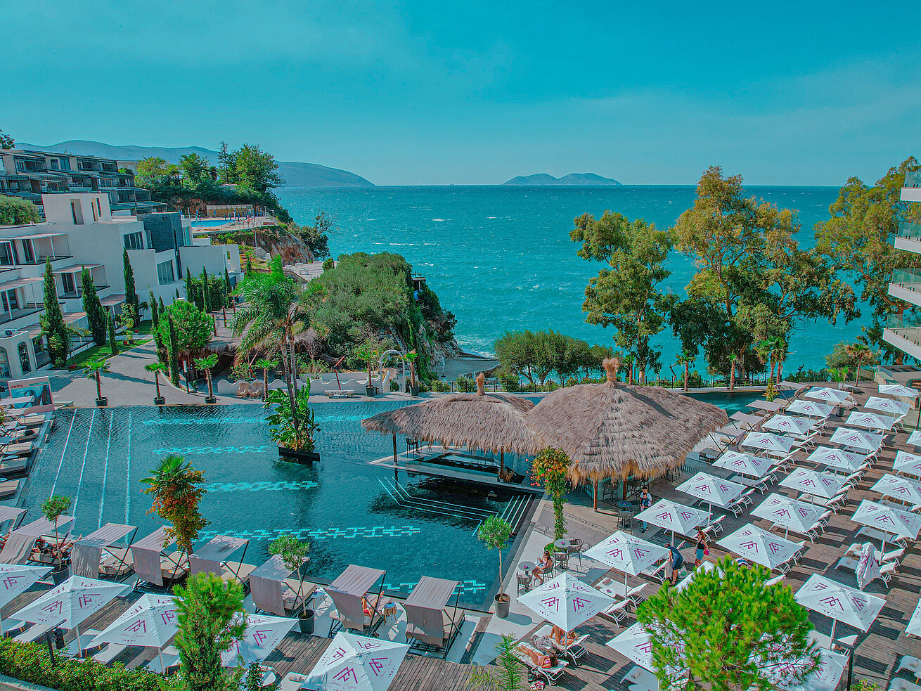 Poollandschaft mit Sonnenschirmen und Meerblick im Maritim Resort Marina Bay