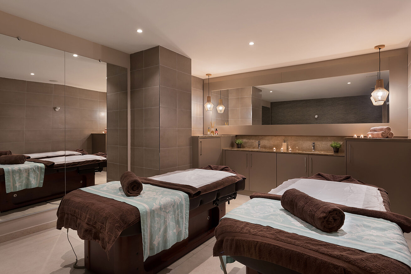Spa- und Massagebereich Eleganter Spa-Bereich im Maritim Antonine Hotel & Spa Malta mit zwei Massageliegen, warmem Ambiente und entspannender Wohlfühlatmosphäre.