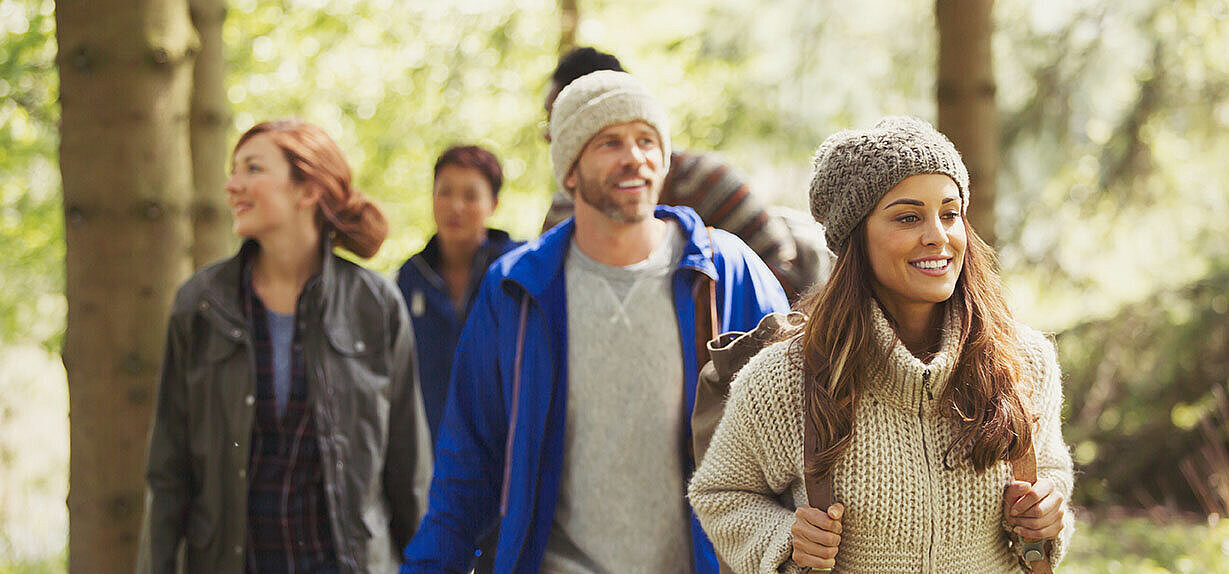 Gruppe von Freunden wandert im Wald und genießt die Natur