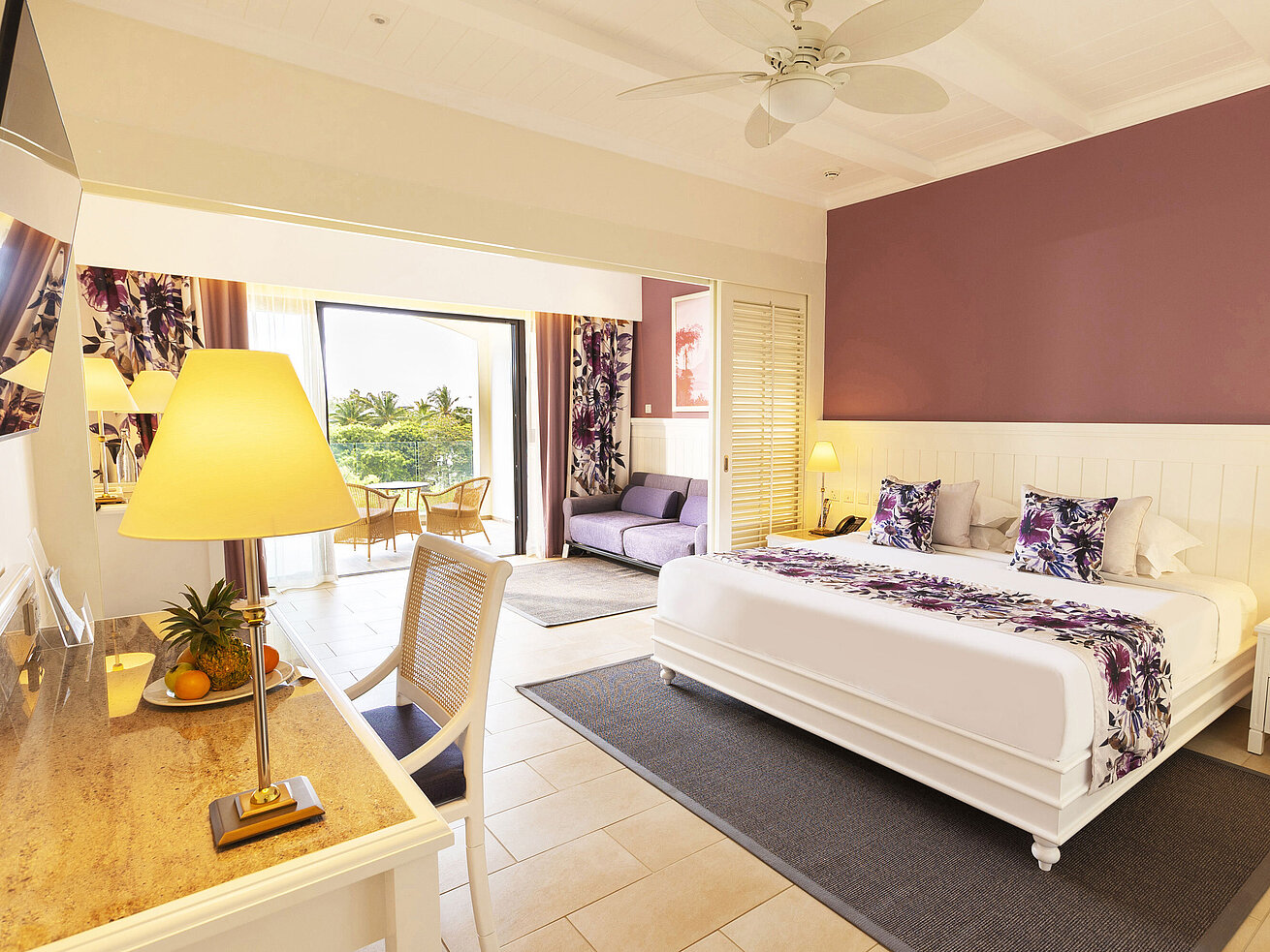 Zimmer mit einem Kingsize-Bett, stilvollen Möbeln und Zugang zur Terrasse mit Meerblick